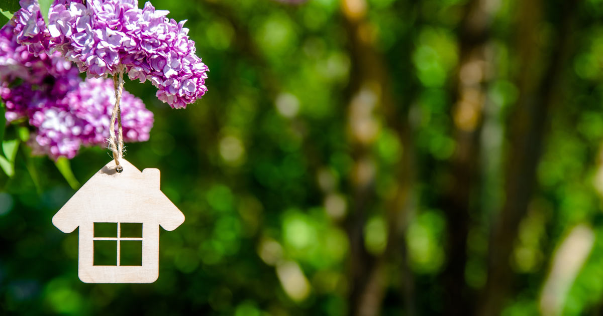 wooden house ornament hanging on purple flowers