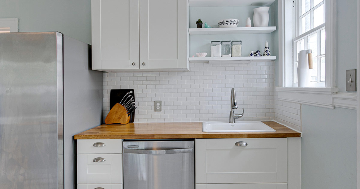 white kitchen with open shelving and silver appliances