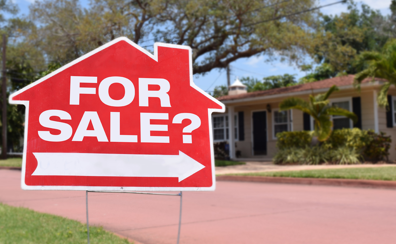 House with a for sale sign in the yard.