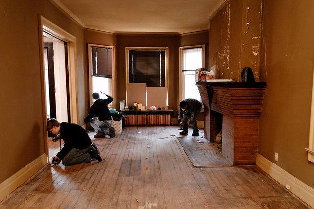 Workers fixing a house with liquid foundation. 