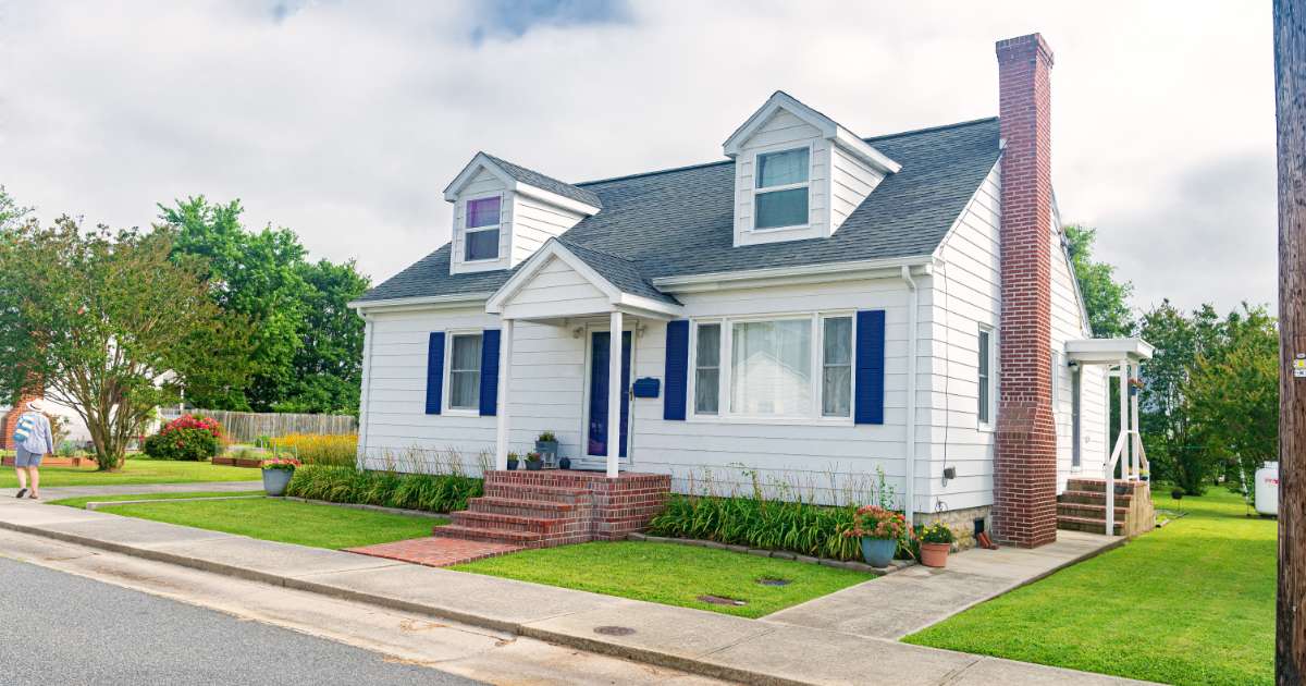 white house with blue shutters and red brick steps